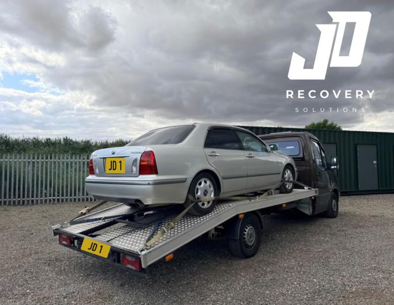 Silver saloon strapped down on the recovery truck