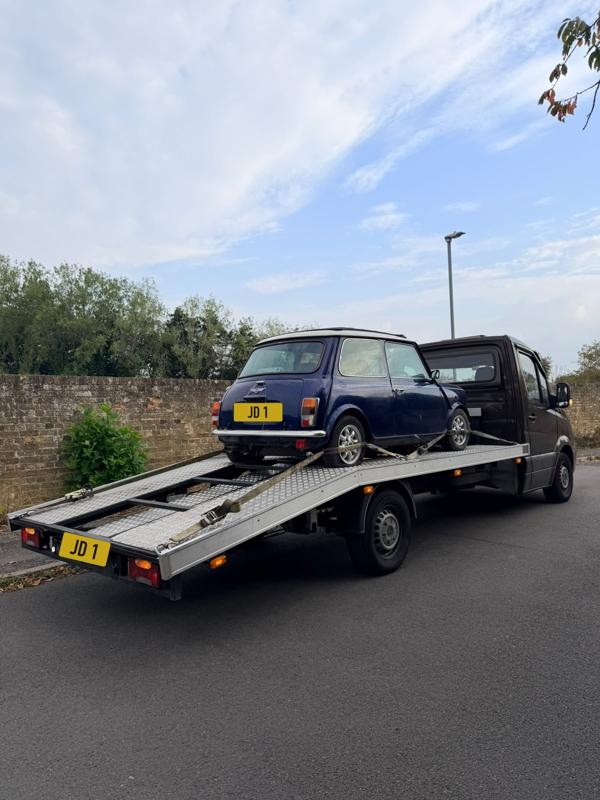 Classic Mini strapped down on the recovery truck